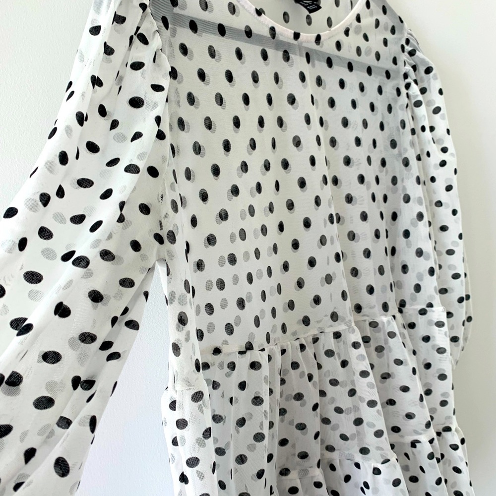 Mesh polka dot peplum, puff sleeve top in black and white.